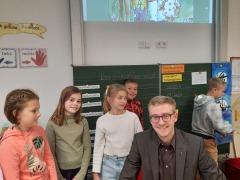 Tobias-Pastoetter-umringt-von-Kindern-der-3a